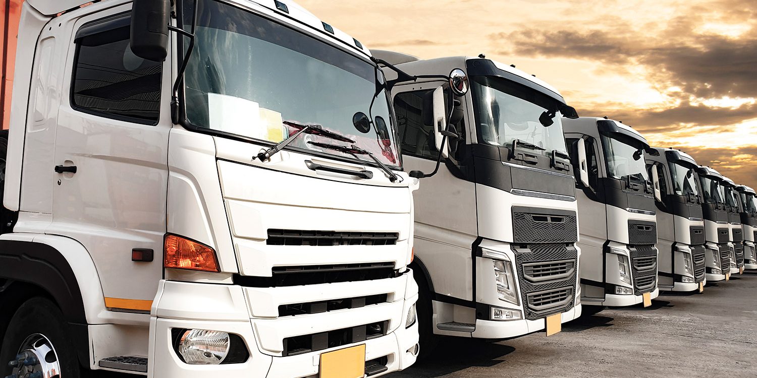 trucks-parked-lined-up-sunset-sky-road-freight-industry-logistics-transport_k